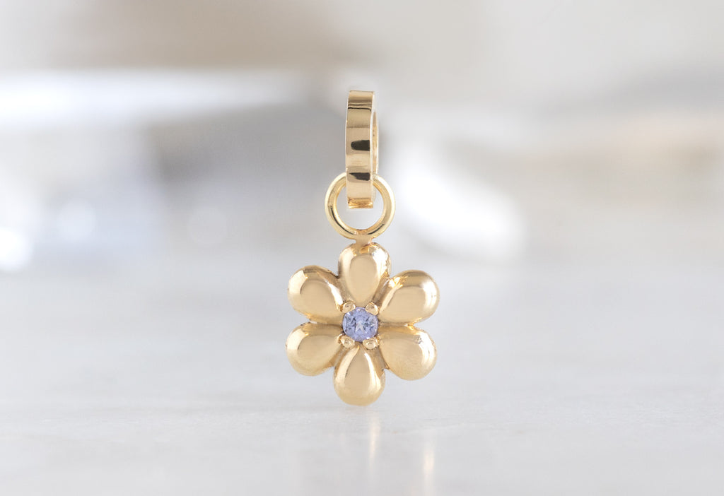 10k Yellow Gold Flower Charm on White Marble Tile