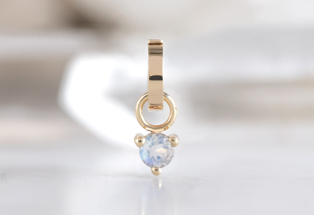 10k Yellow Gold Moonstone Birthstone Charm on White Marble Tile