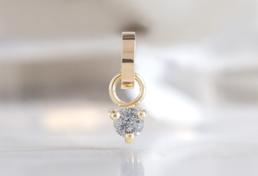 10k Yellow Gold Diamond Birthstone Charm on White Marble Tile