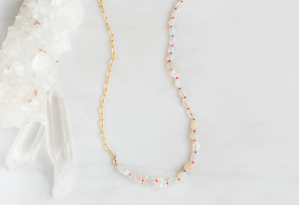 Knotted Opal Necklace on White Marble Tile