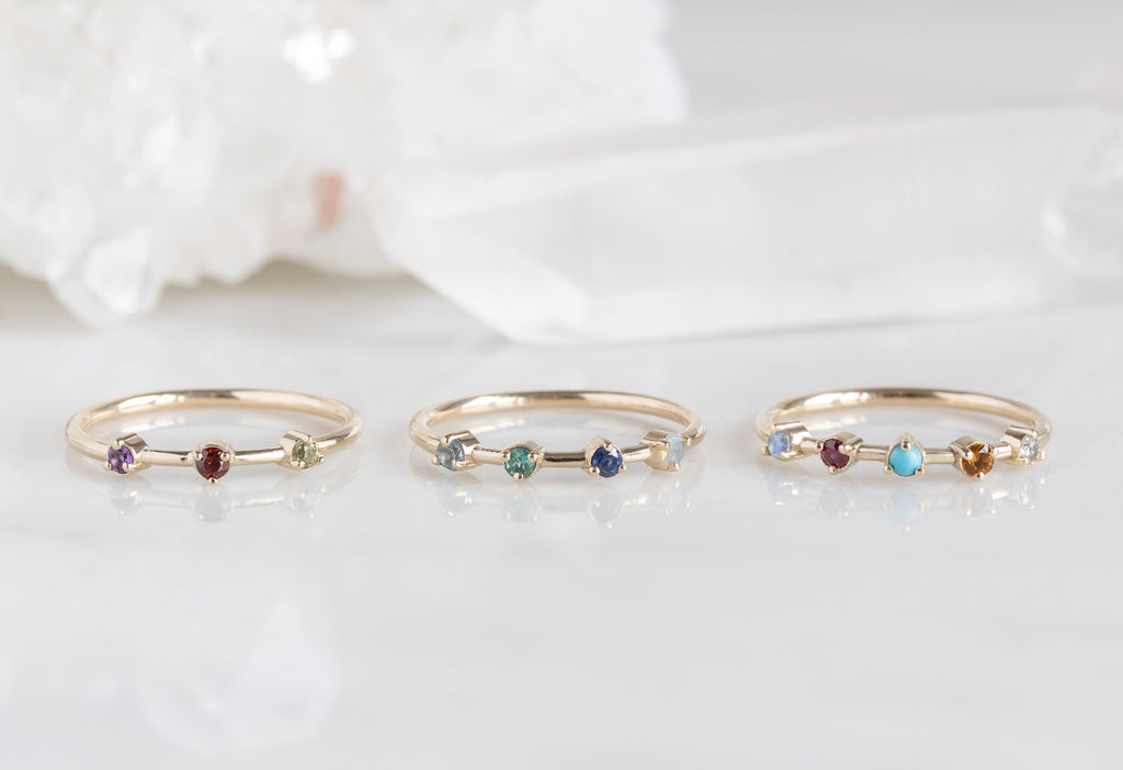 Custom Multi-Birthstone Rings on White Marble Tile