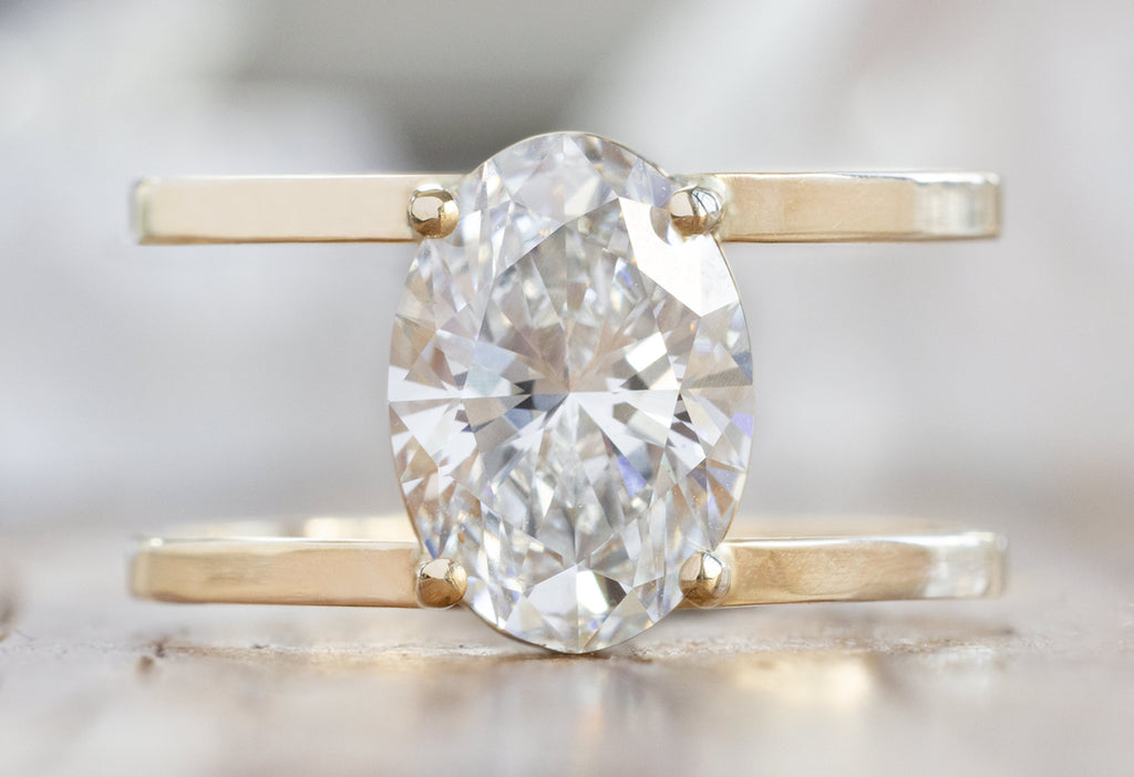 The Poppy Ring with an Oval-Cut Lab Grown Diamond on Wood Table