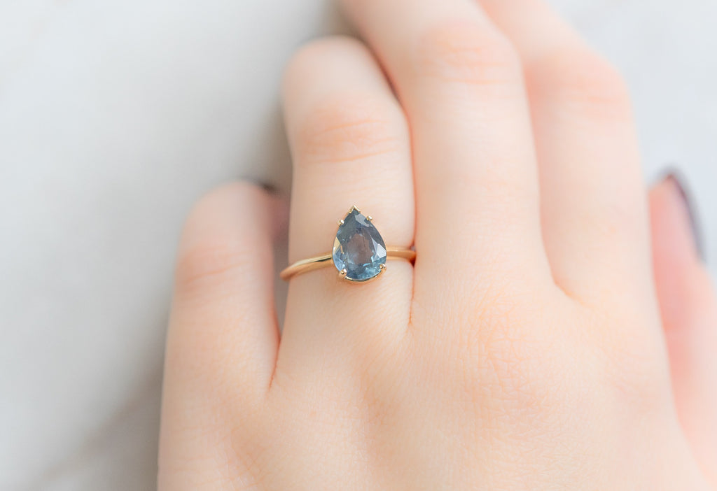 The Sage Ring with a Pear-Cut Montana Sapphire on Model