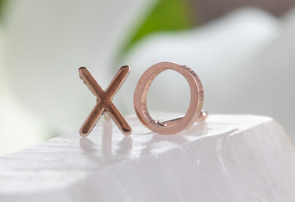 rose gold 'xo' stud earrings on white crystal 