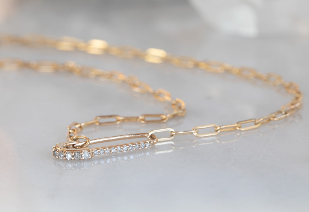 Yellow Gold Pavé Diamond Pin Necklace on White Marble Tile