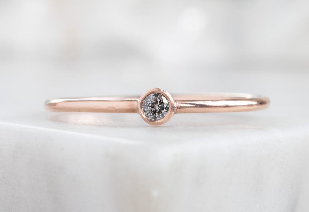 Rose Gold Teensy Custom Diamond Stacking Ring on white marble tile