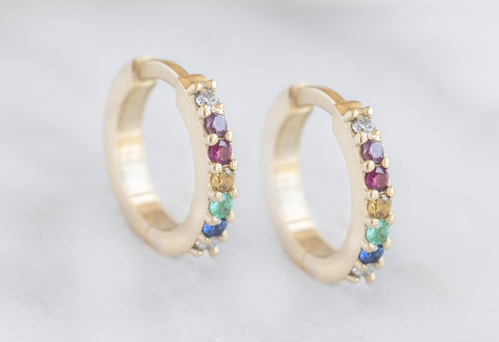 Pavé Rainbow Huggie Hoops Standing Upright on Marble