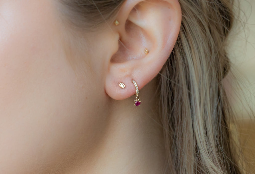 Ruby + Diamond Huggie Studs in Second Hold on Model's Ear